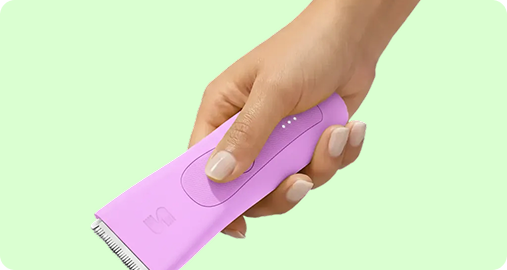 Hand holding a pink LADYSPOT body trimmer for shop all products