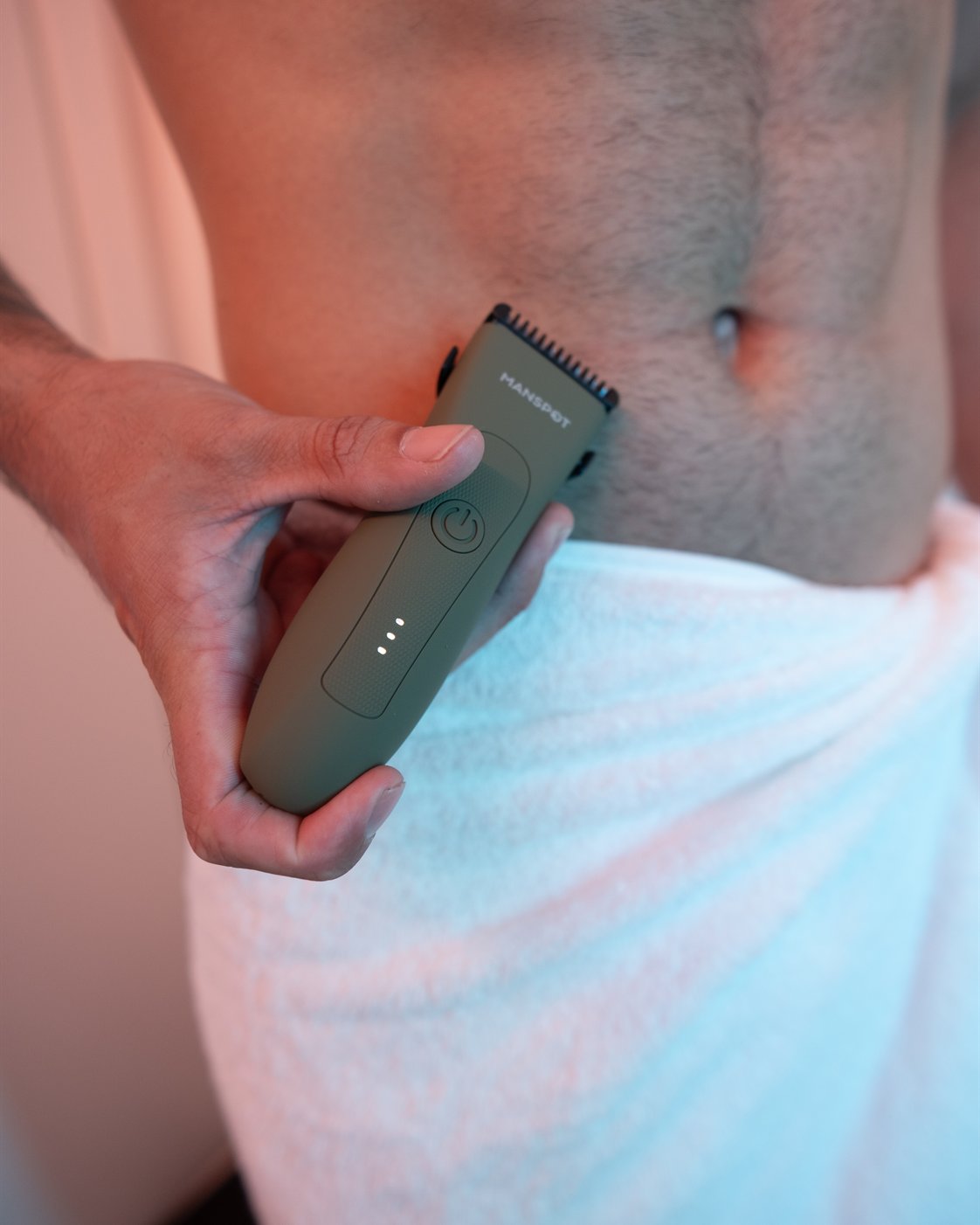 Man using a MANSPOT trimmer for discreet body grooming